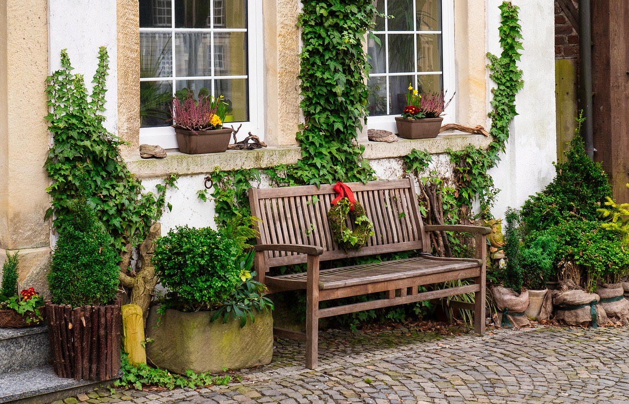 Banc en bois devant une façade fleurie